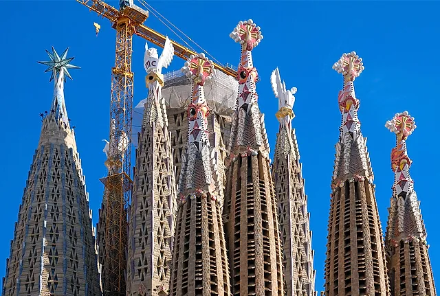 Close view of the colourful pinnacle tops of the towers, crowned with stars and doves, against a deep blue sky